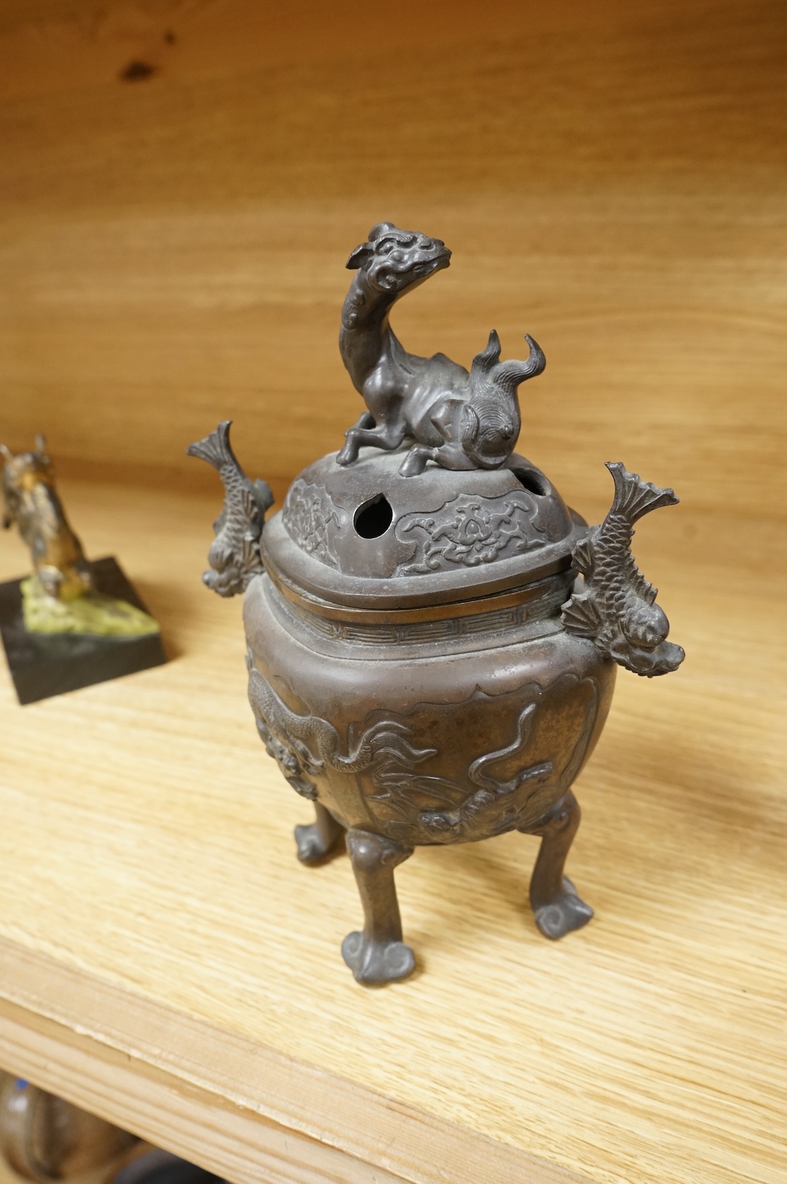 A Japanese bronze koro, raised on four feet with zoomorphic handles and knop, 23cm high